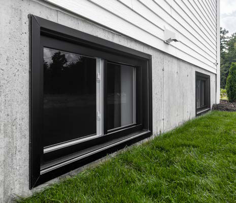 Fenêtre coulissante noire au sous-sol d'une maison