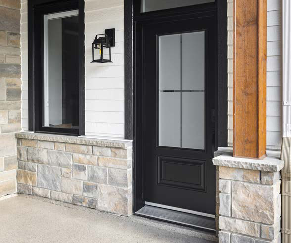 Porte d'entrée en acier noire vitrée sur une galerie de pierre