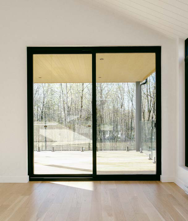 Porte patio coulissante noire ouvrant sur une terrasse