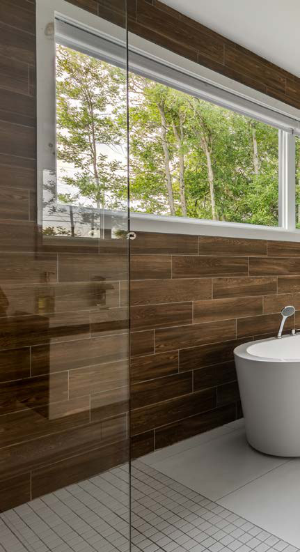 Fenêtre horizontale au-dessus d'un bain, mur de céramique imitation bois