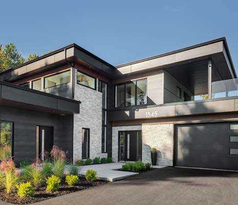 Maison contemporaine de pierre et de bois aux grandes fenêtres noires