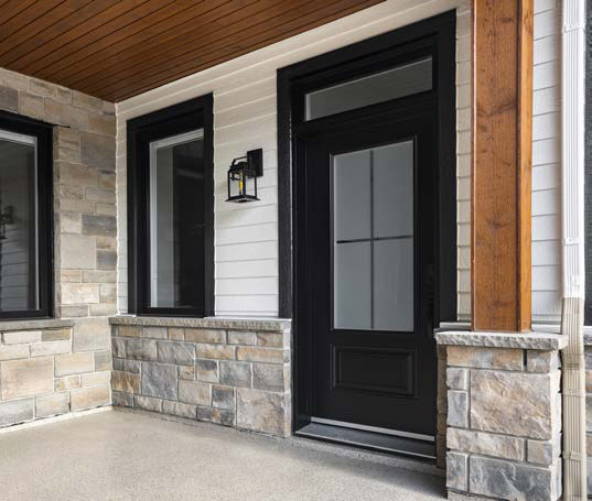 Porte d'acier noire vitrée sur une galerie de pierre