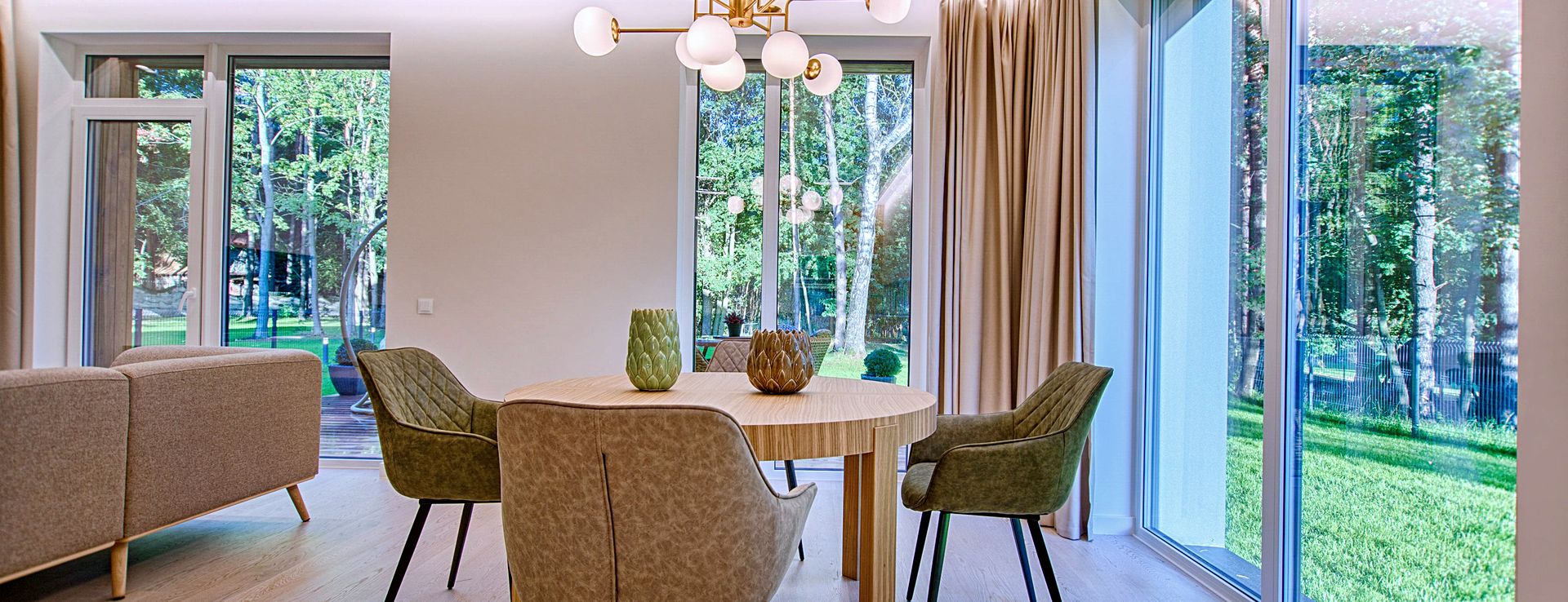 Salle à manger lumineuse ouverte sur un jardin par de grandes fenêtres au vitrage clair