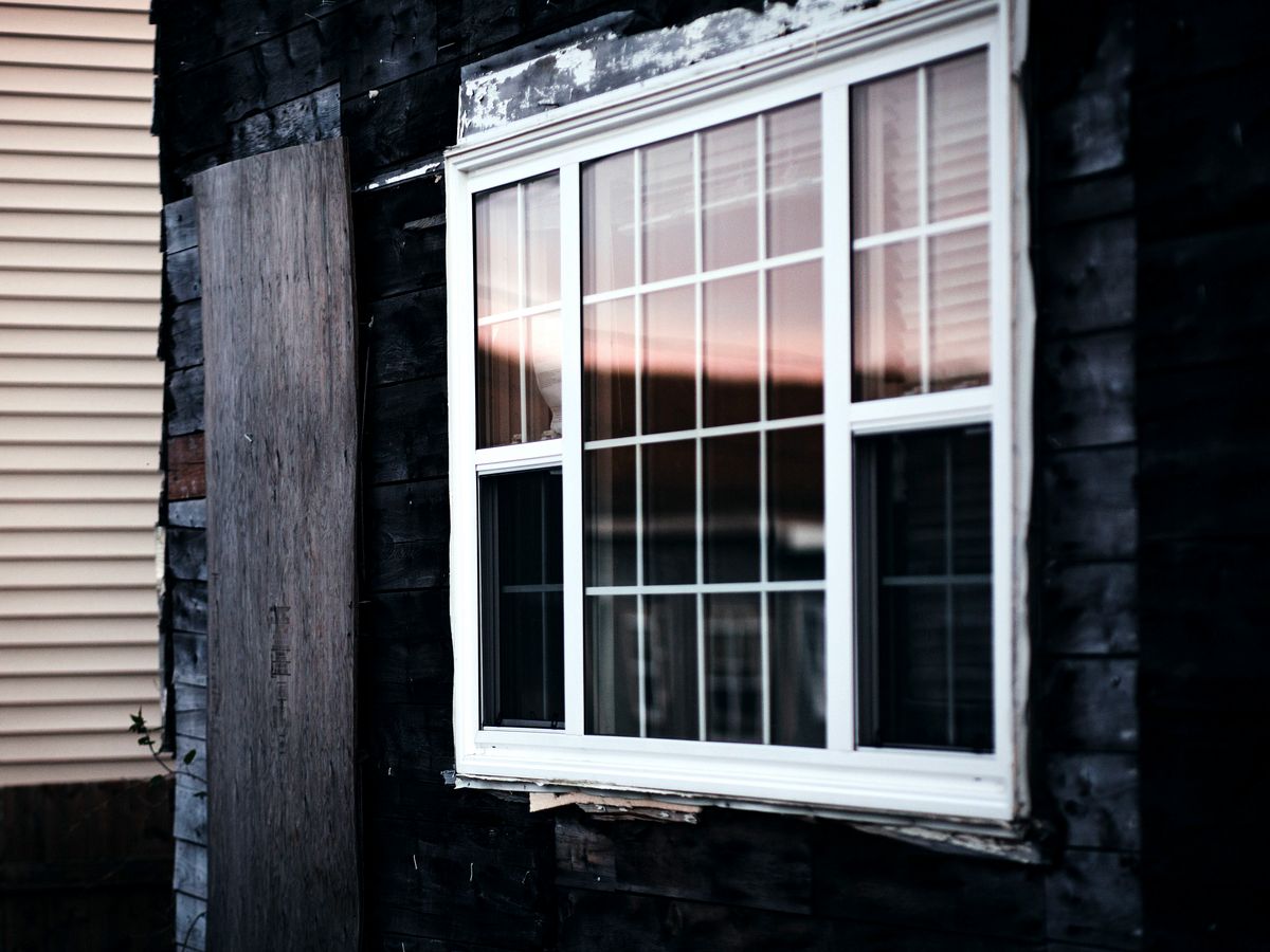 Fenêtre blanche à carrelage posée dans un revêtement de bois sombre