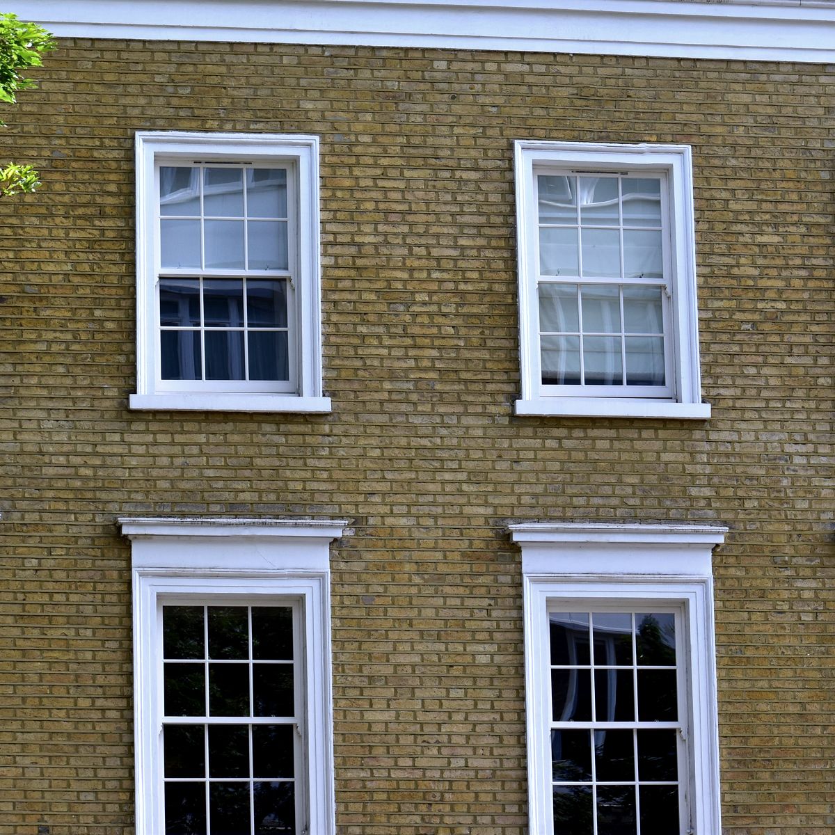 Façade de brique aux fenêtres à guillotine blanches à petits carreaux